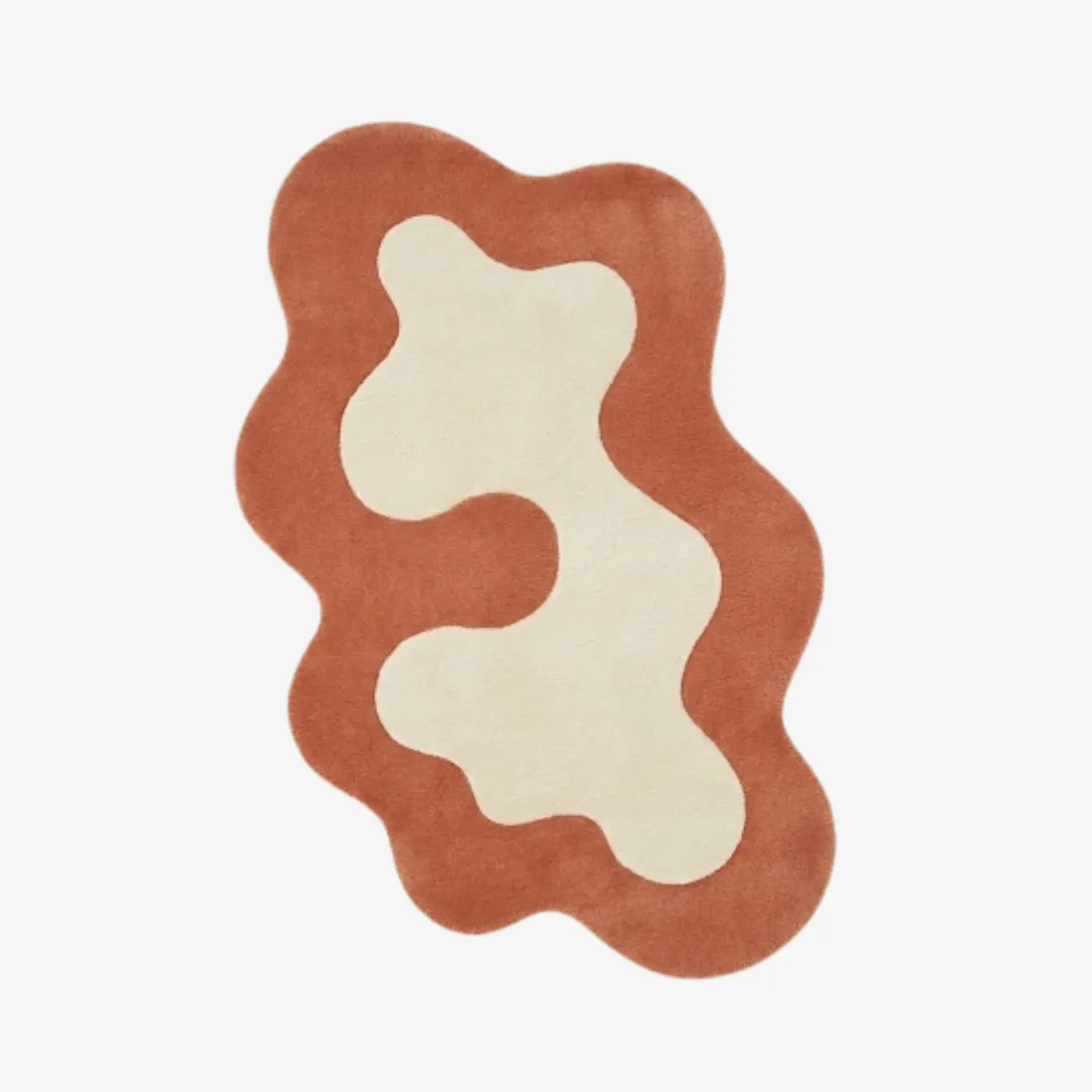Top-down view of the Terrand Form rug against a white background, featuring a fluid, organic wavy silhouette with a bold terracotta orange border surrounding a central cream-colored abstract shape.