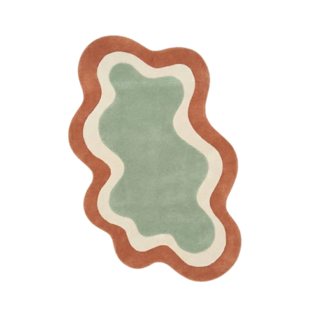 Top-down view of the Wellonest rug featuring a fluid, organic wavy silhouette with nested layers of sage green, ivory, and terracotta orange.