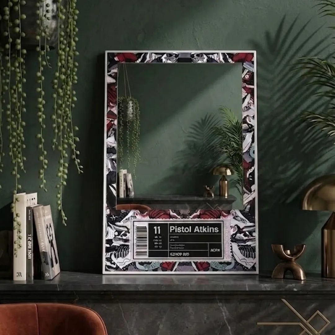 A vertical mirror featuring a custom "Pistol Atkins" sneaker-themed graphic border on a dark green mantle, surrounded by books and hanging ivy, reflecting a warm lamp and modern room interior.