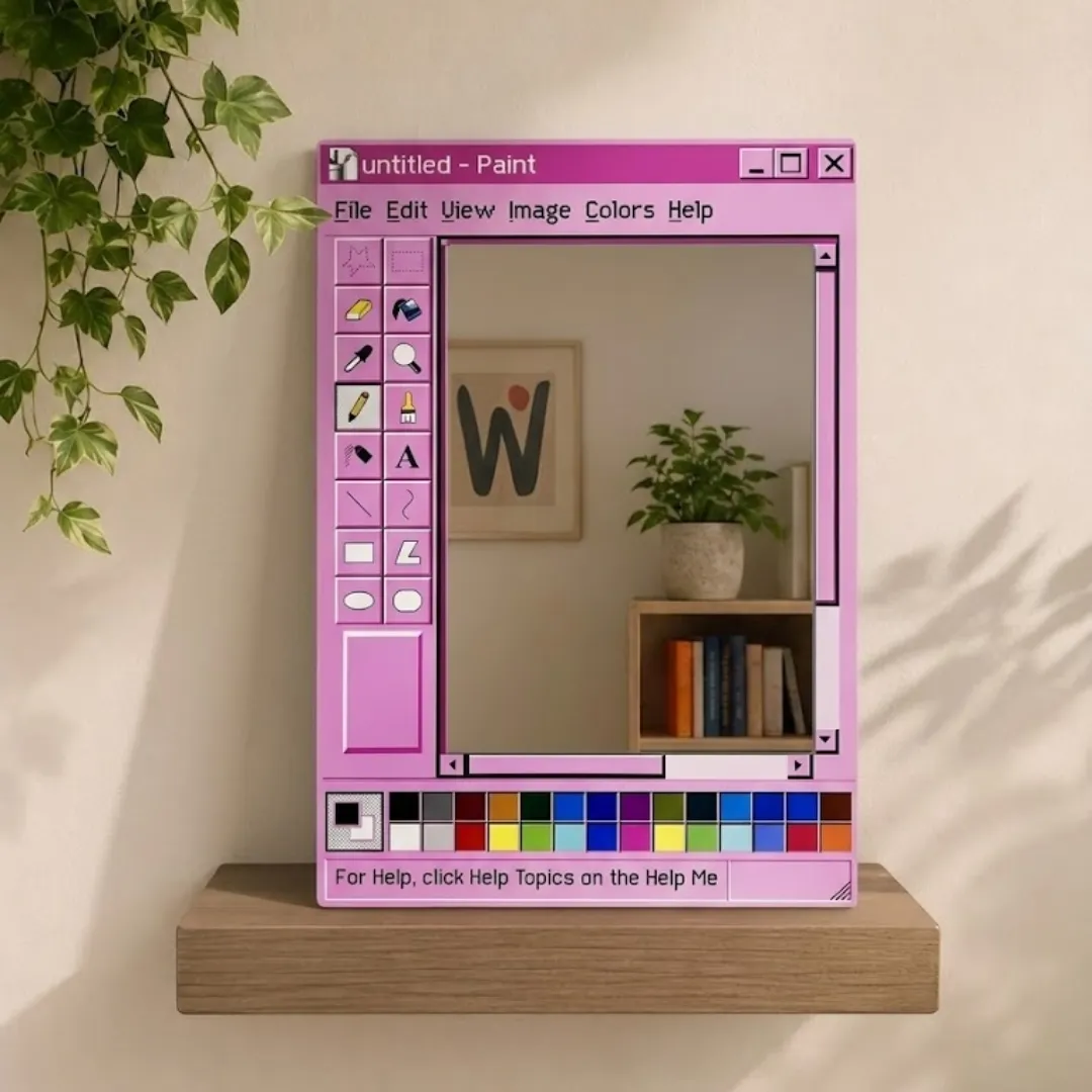 Front-facing shot of the Paint Frame mirror, designed to look like the vintage MS Paint software interface, displayed on a wooden shelf with a hanging plant.