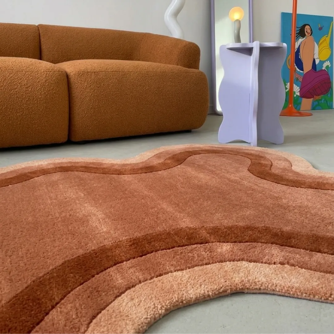 Close-up of the plush tufted pile texture and rich terra cotta and clay color transitions on the Arden Clay rug.