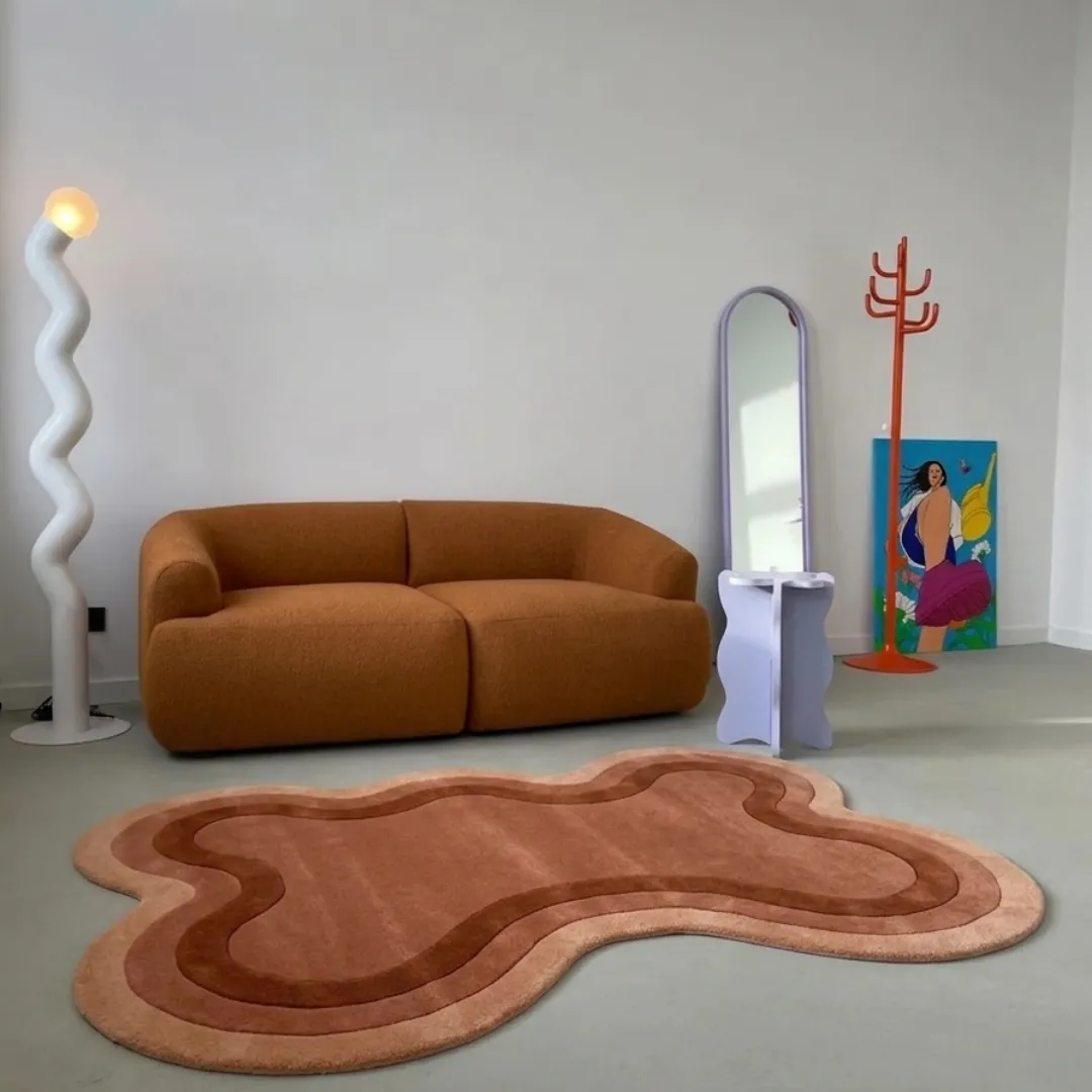 Arden Clay modern organic terracotta area rug styled in a contemporary living space with a warm brown sofa and modern decor.