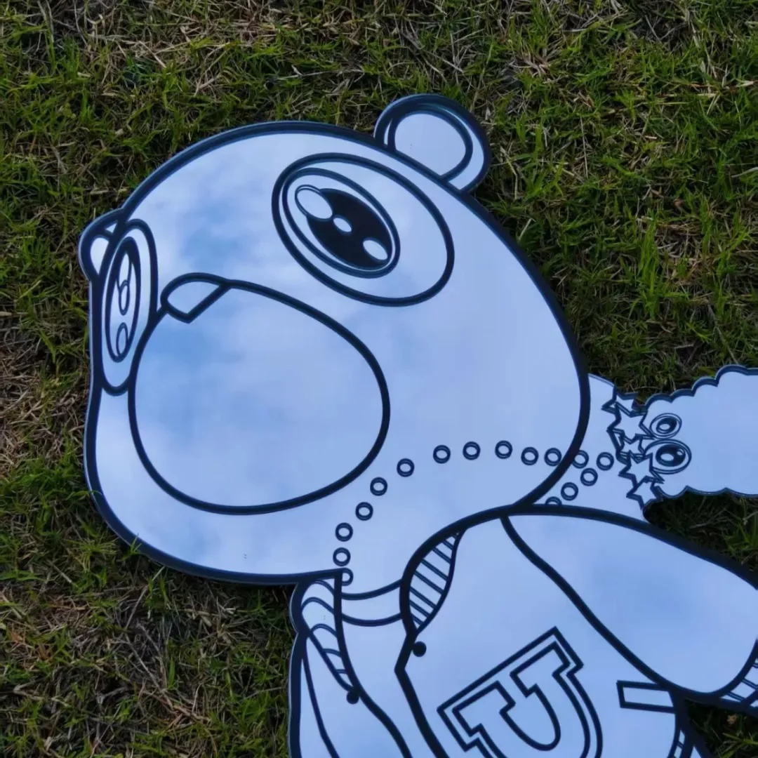 bear dropout full figure mirror grass view Bear Dropout full-figure cartoon bear wall mirror laid flat outdoors on a patch of green grass.