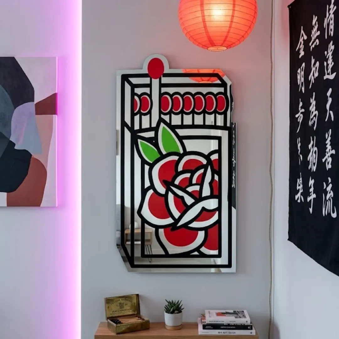 Cherry Blossom decorative wall mirror featuring a matchbox design with traditional tattoo-style red rose art and matches, mounted above a shelf on a white wall.