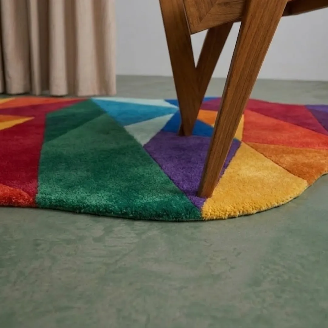 chromatic drift rug close up texture Close-up of the plush tufted pile texture, vibrant geometric color blocking, and wooden chair leg on the Chromatic Drift rug.