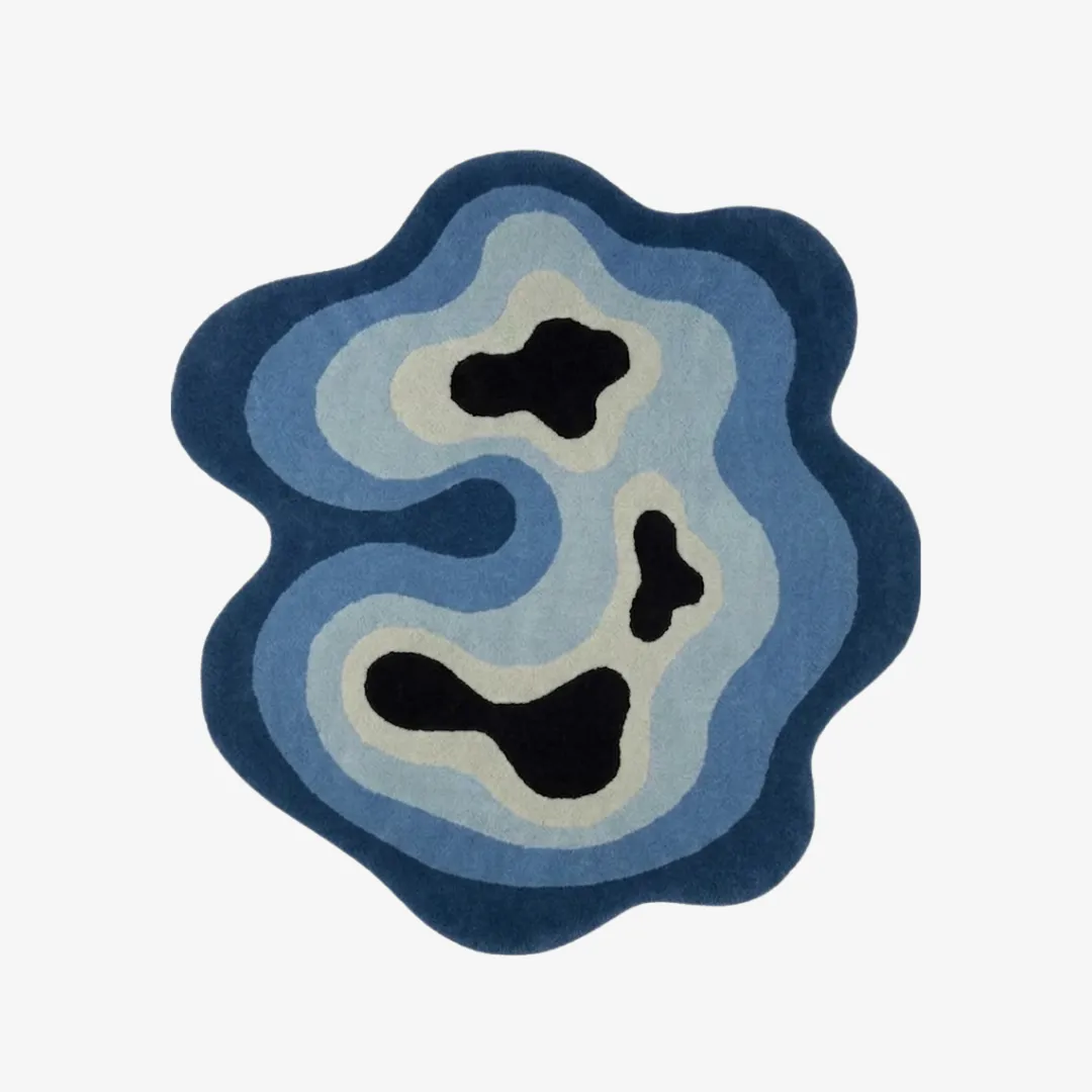 Deep Tide organic irregular-shaped tufted area rug featuring abstract blue and black topographic wave patterns, displayed flat.
