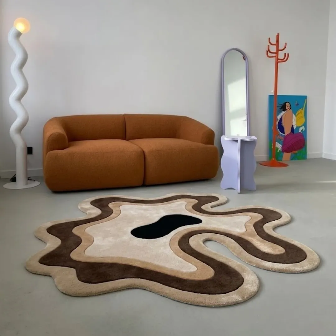 Desert Flow modern organic earth-toned area rug styled in a contemporary interior room with a brown sofa and minimalist decor.