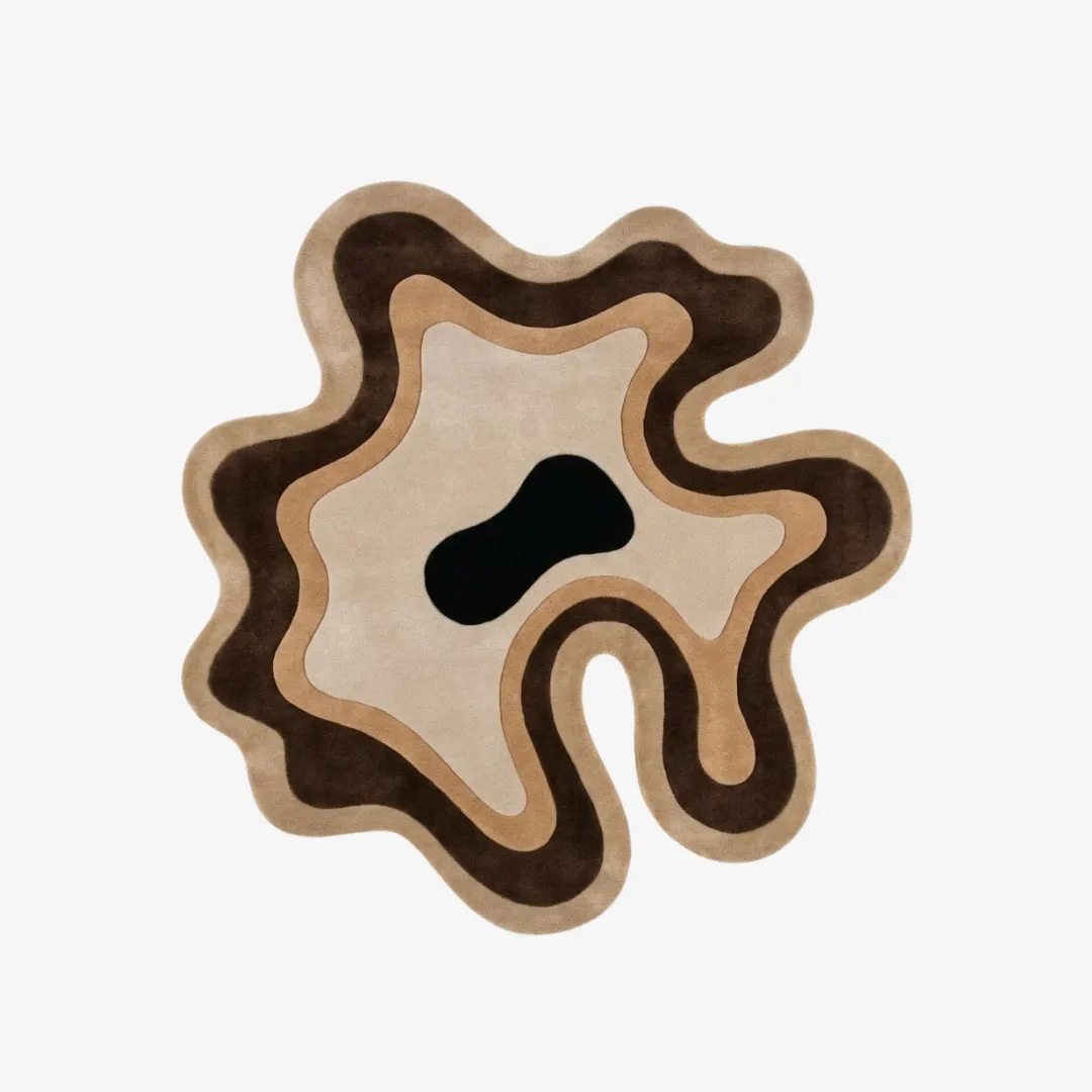 Desert Flow organic irregular-shaped tufted area rug featuring abstract earth-toned topographic waves in brown, tan, and cream with a central black accent, displayed flat.