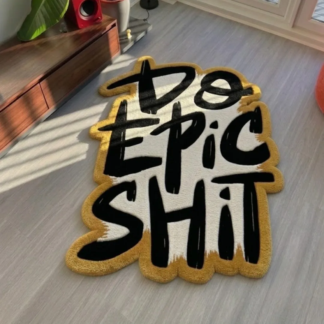 Do Epic Shit handmade tufted area rug featuring bold black typography on a white and mustard yellow background, displayed flat on a light wood floor.