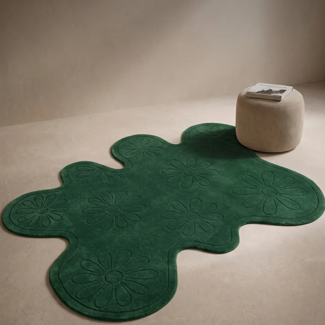 fern valley rug room mockup Fern Valley botanical green area rug styled in a modern minimalist neutral interior with a textured pouf.