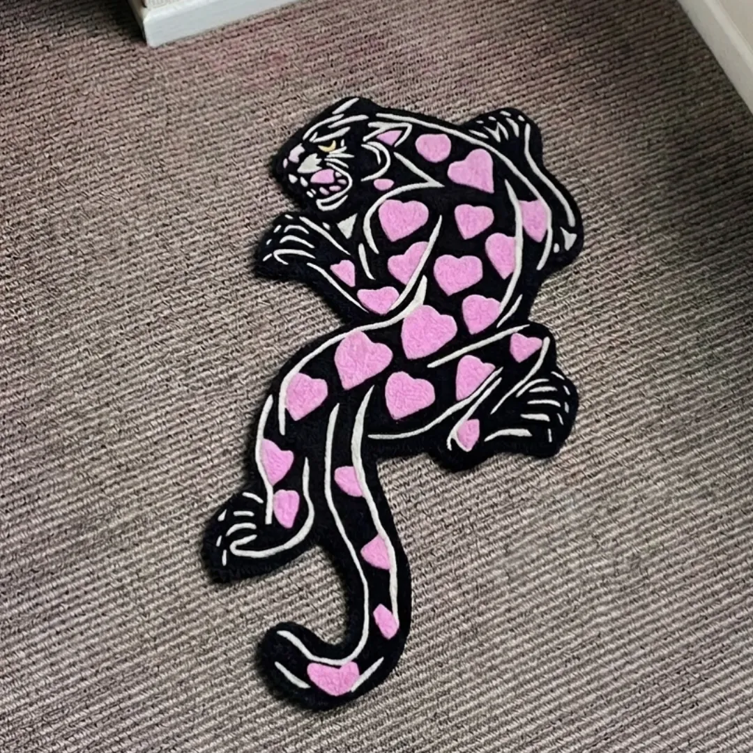 heart panther rug top view Heart Panther handmade tufted area rug featuring a black panther design with pink heart spots and white outlines, displayed flat on a carpeted floor.