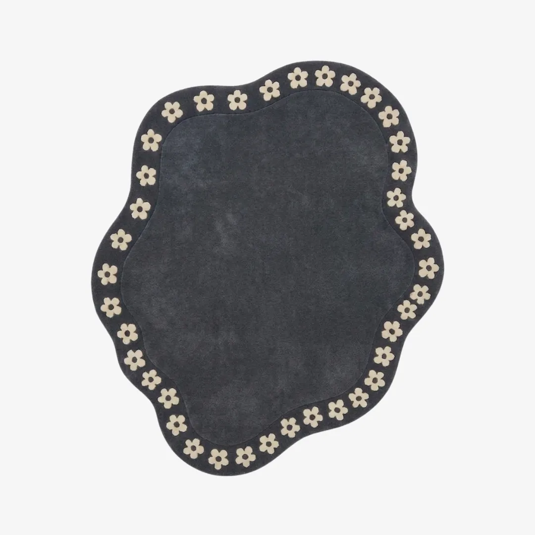 luna meadow rug top view Luna Meadow charcoal grey organic irregular-shaped tufted area rug featuring a border of white daisy flower motifs, displayed flat.