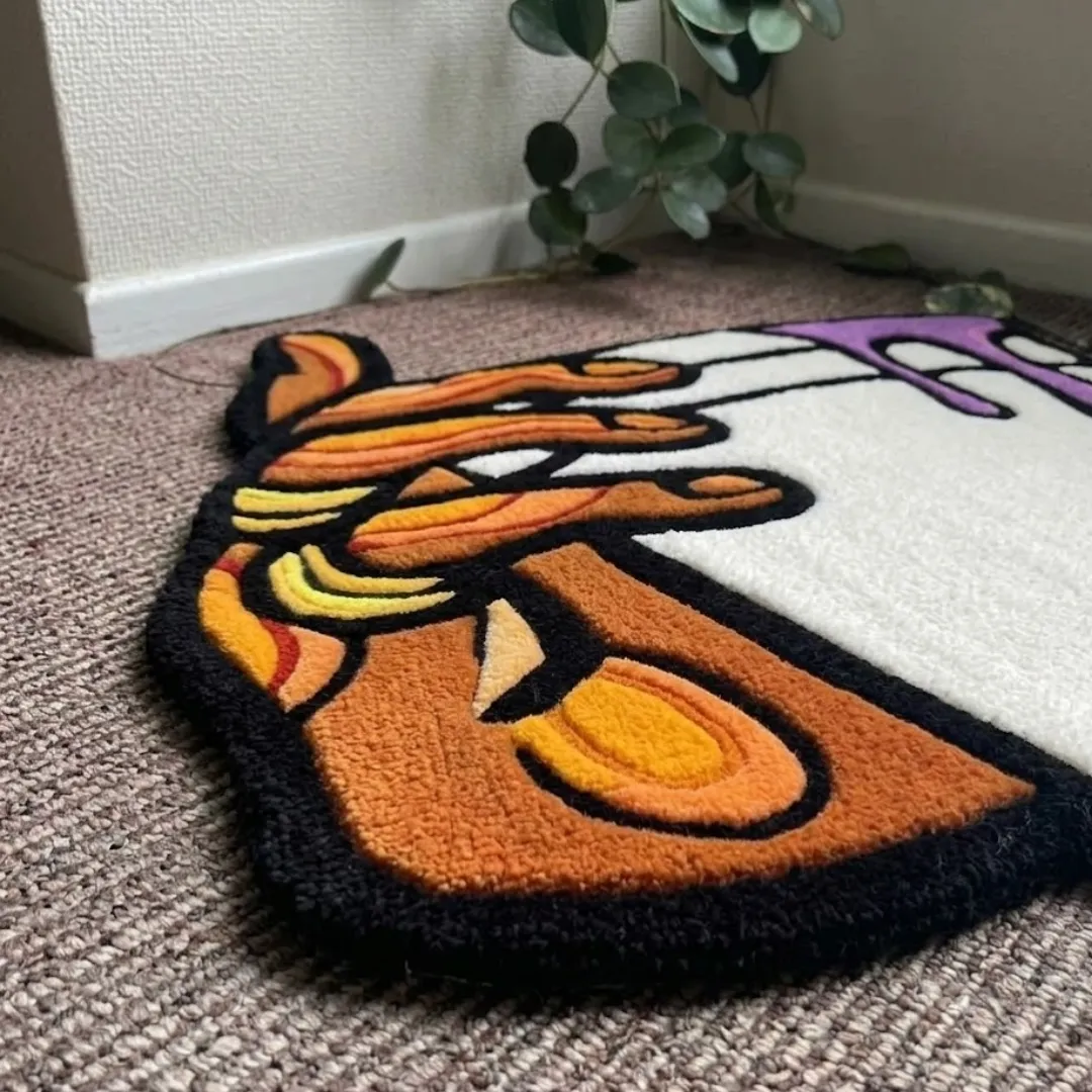 melting cup rug angle view Angle view of the Melting Cup tufted rug showcasing its detailed hand design, bold black linework, and vibrant orange and yellow tones.