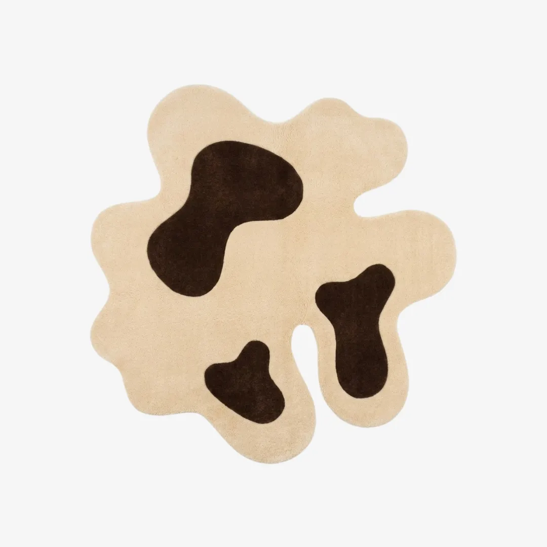 oat muse rug top view Oat Muse organic irregular-shaped tufted area rug featuring a cream base with abstract dark brown cow-print spots, displayed flat.