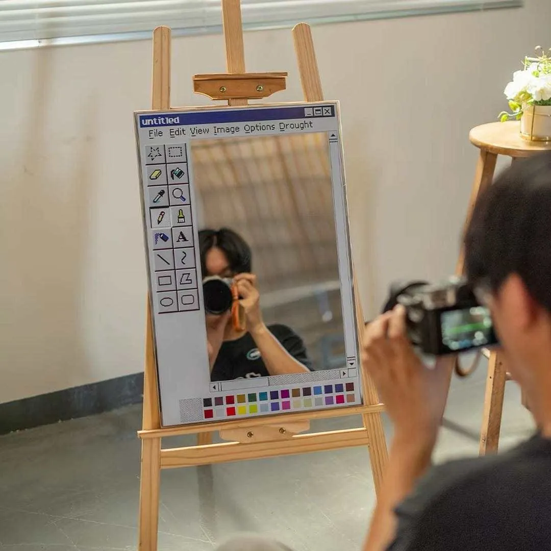 paint window mirror easel mockup Paint Window application interface mirror displayed on a wooden artist easel in a bright creative studio setting.