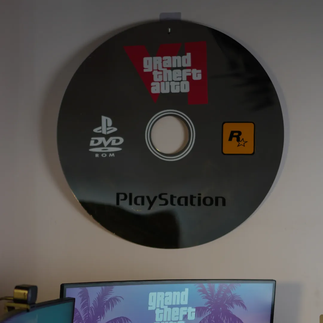 Retro Disc novelty gaming disc wall mirror styled above a computer monitor in a modern gaming setup room.