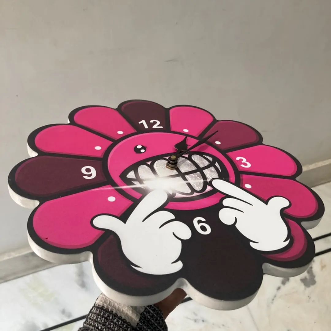 smiley bloom clock angle view Angle view of the Smiley Bloom shaped wall clock showcasing its vibrant pink flower petals and dimensional design.
