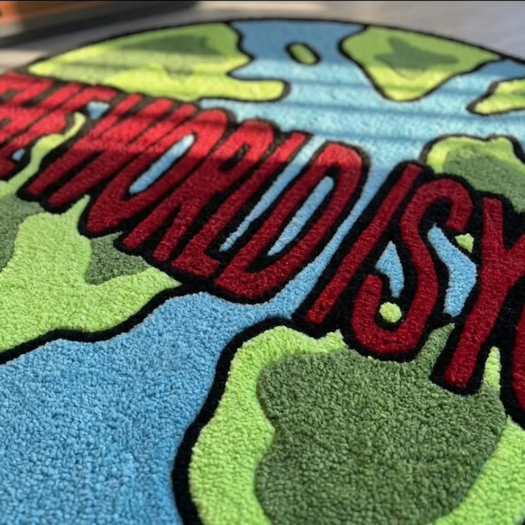 the world is yours rug close up texture view Close-up macro texture shot of the high-density tufted wool pile, carved contours, and vibrant red, blue, and green color blocks on The World Is Yours rug.