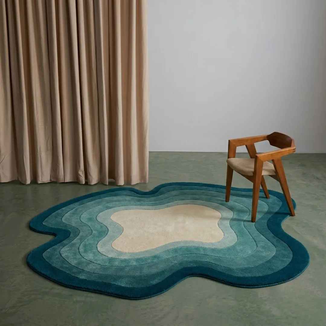 tidal ombre rug room mockup Tidal Ombre modern organic blue area rug styled in a contemporary interior room with a wooden chair and beige curtains.