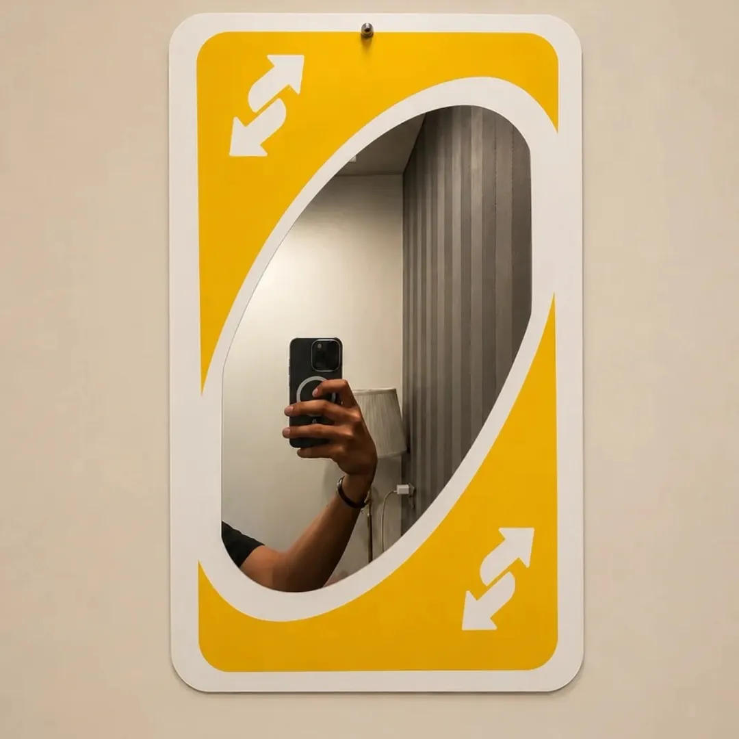 Yellow Flip Card decorative wall mirror designed like a classic yellow Uno reverse card, reflecting a person taking a mirror selfie.