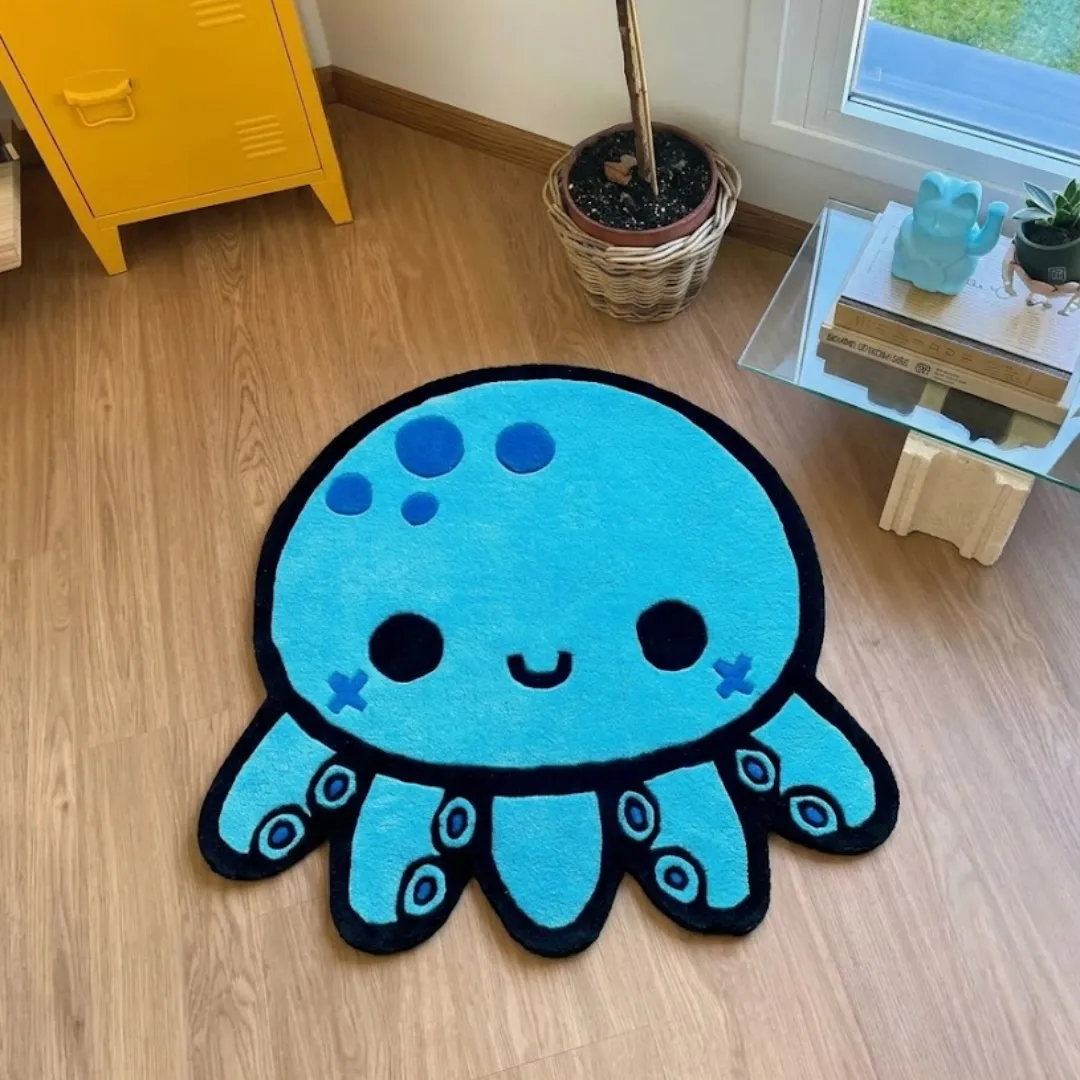 aqua mallow rug overhead room view Aqua Mallow handmade tufted novelty area rug shaped like a cute blue octopus with big eyes and tentacles, displayed flat on a bright wooden floor.