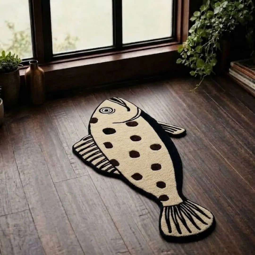 sage sole rug overhead room view Sage Sole handmade tufted novelty area rug shaped like a speckled fish with polka dots, displayed flat on a dark wooden floor near a window.