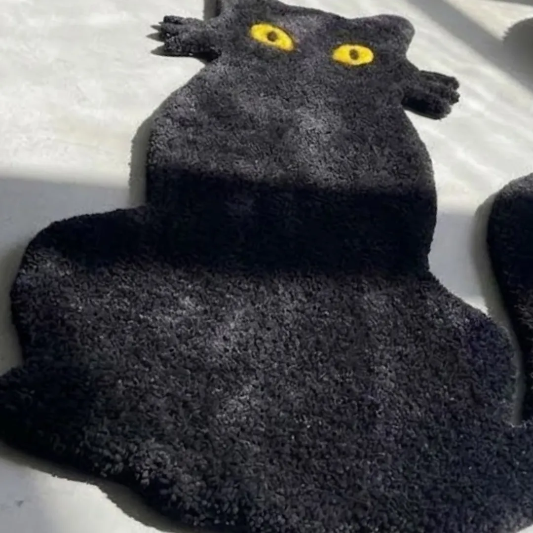 shadow meow rug close up texture view Close-up macro texture shot of the high-density tufted black wool pile and vibrant yellow cat eyes on the Shadow Meow designer rug.